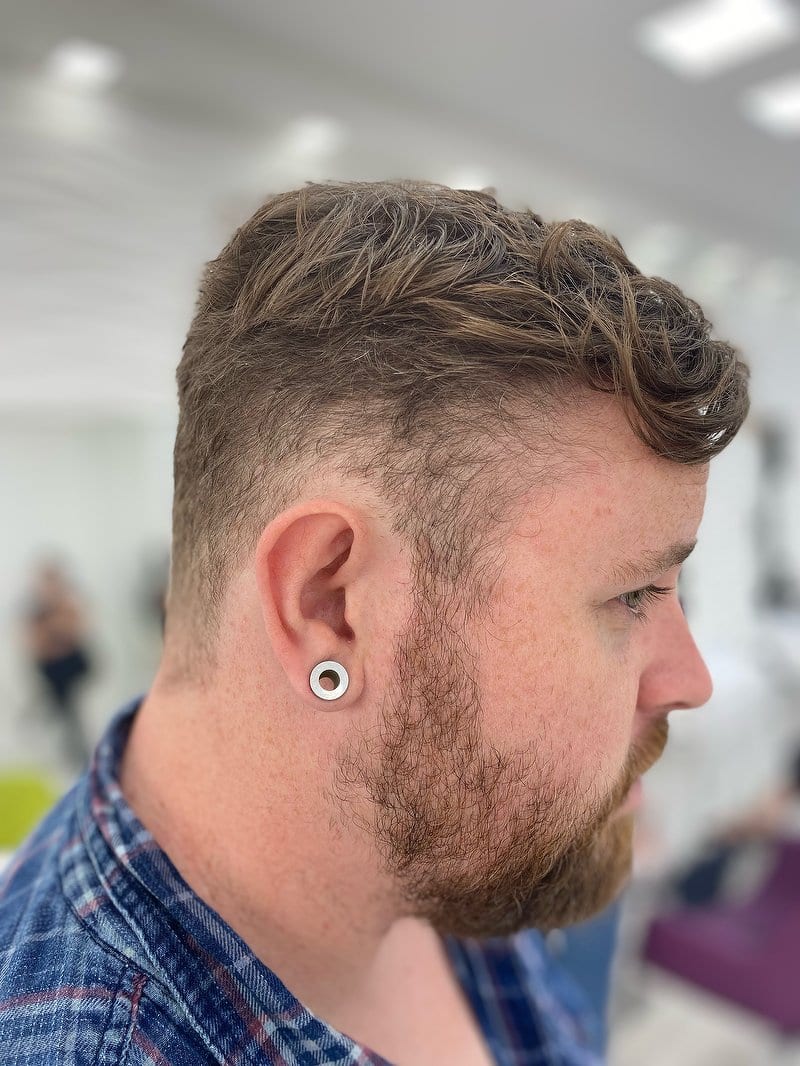 Men's textured quiff with a short faded side and a trimmed beard