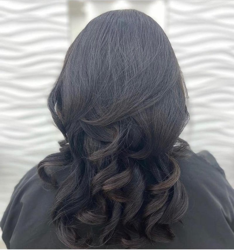 Dark brown layered hair styled into big, voluminous curls