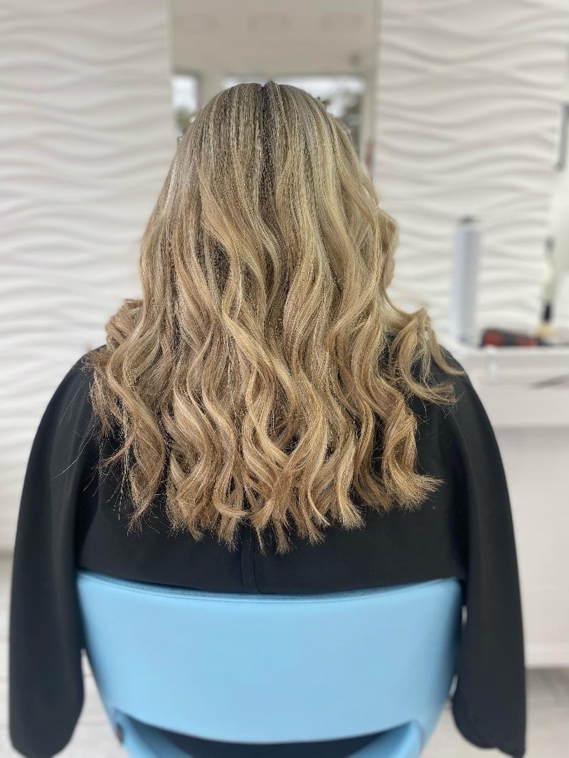 Blonde balayage styled in soft beach waves