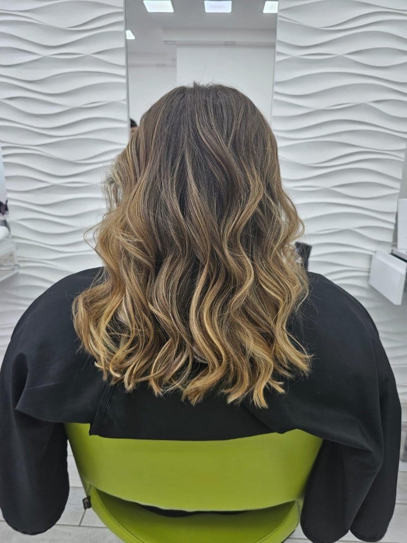 Wavy shoulder-length hair with a blonde ombré