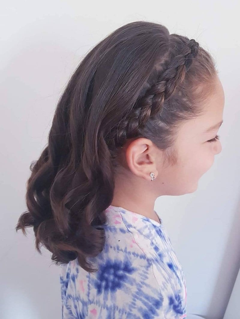 Young girl with a plaited headband braid and curled hair