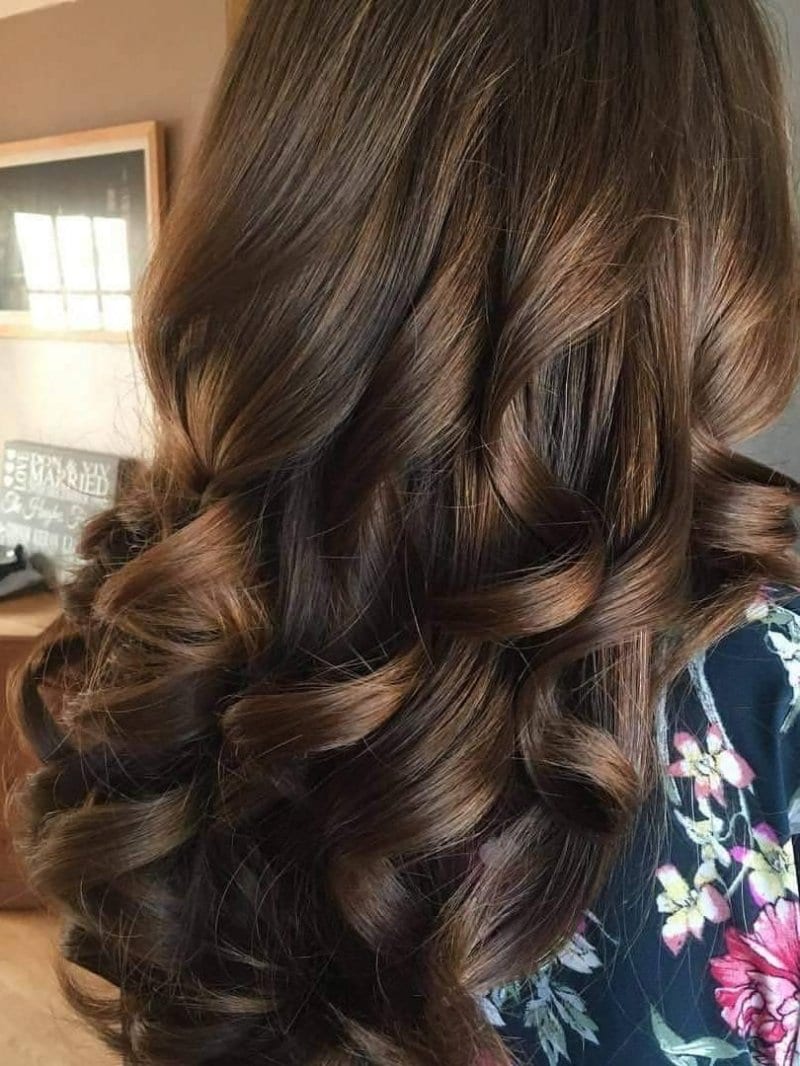 Dark chocolate brown hair styled into glossy loose curls